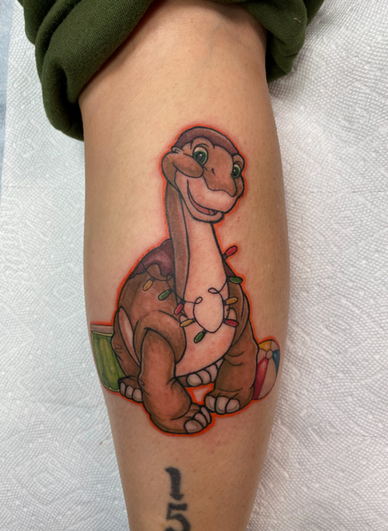 Dinosaur cartoons leg, photo - Tattoo Studio Sacred Tattoo