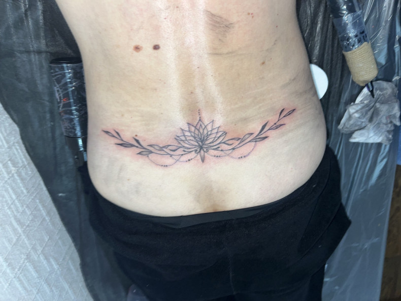 Women lotus flower lower back, photo - Tattoo Master Barb Tattoo