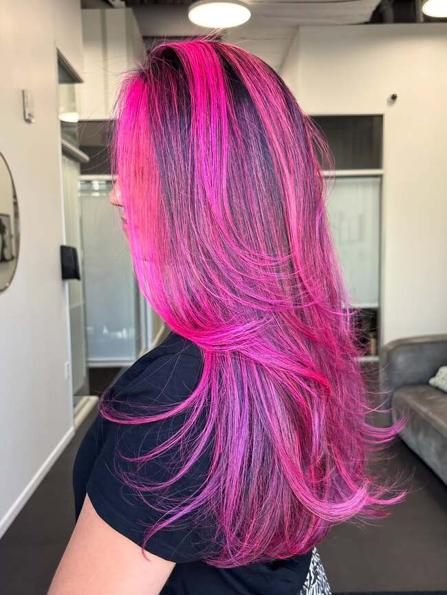 Leuchtende rosa Highlights auf Stufen-Haarschnitt