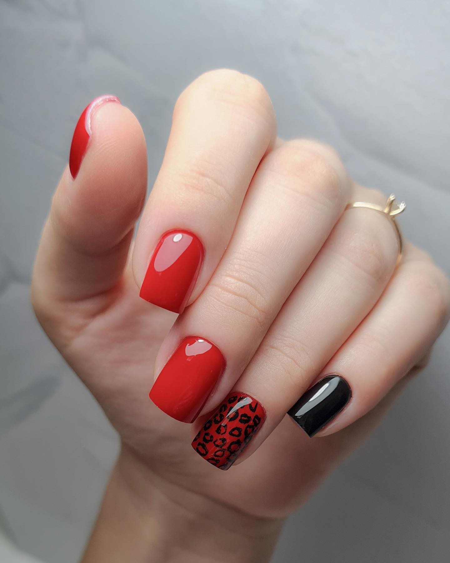 Rote Nägel mit schwarzen Mustern