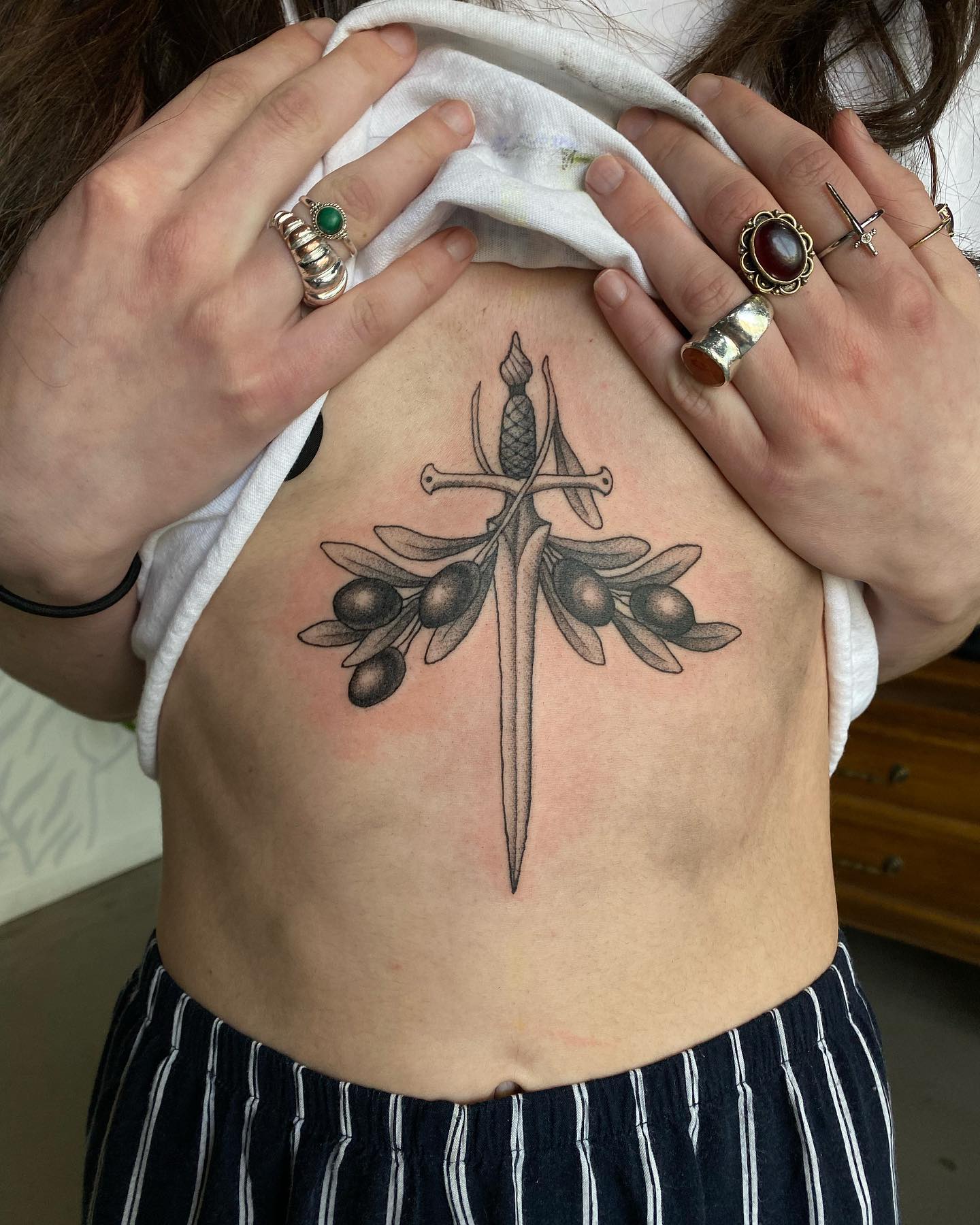 Tatuaż mostka z mieczem i oliwką