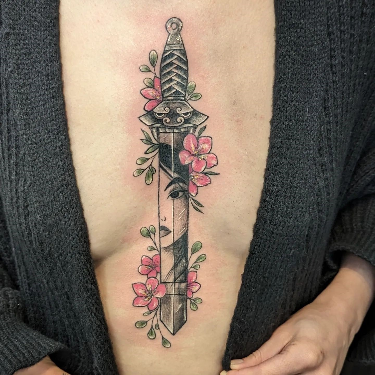 Stary tatuaż na mostku z mieczem