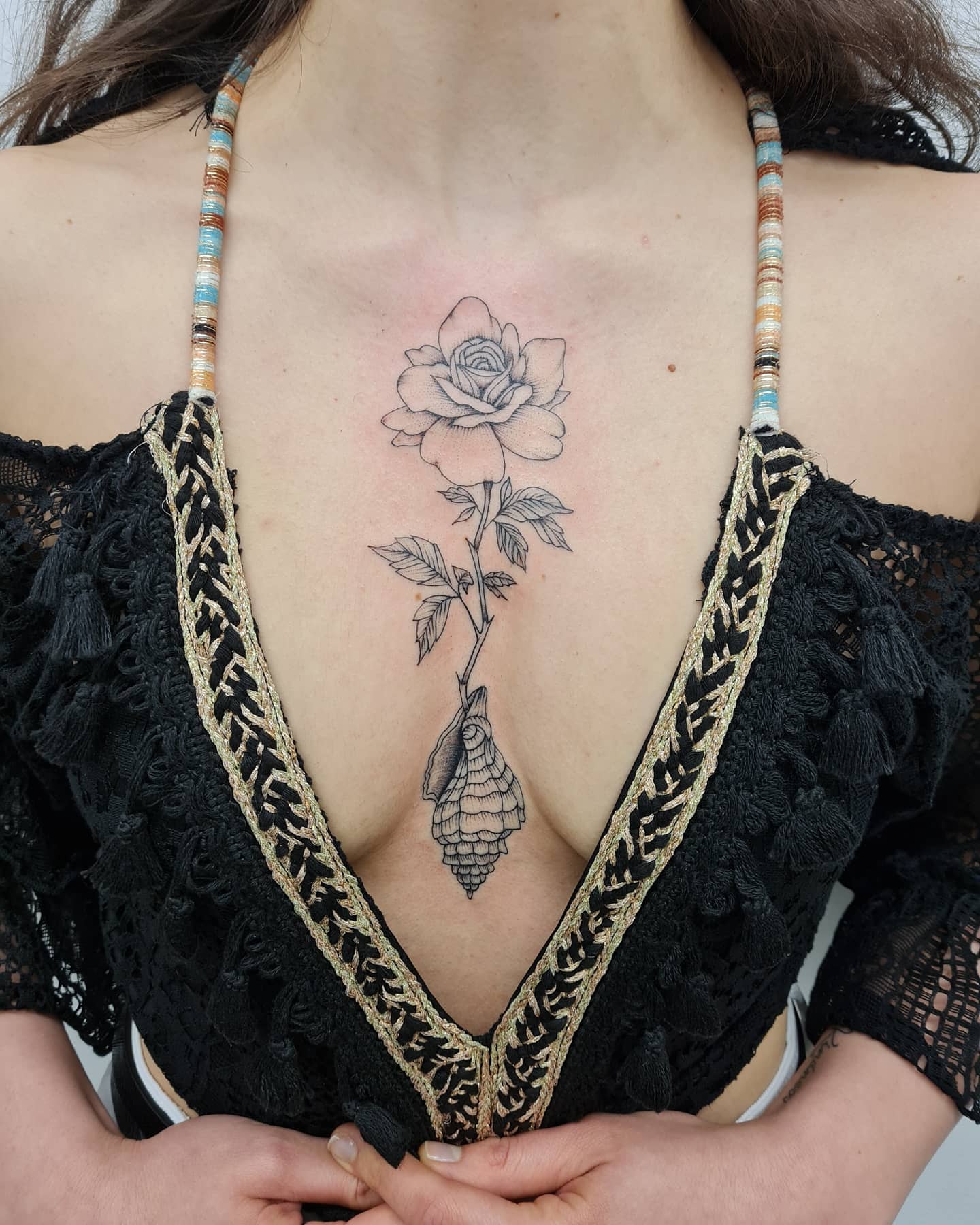 Kobiecy tatuaż z różą na mostku