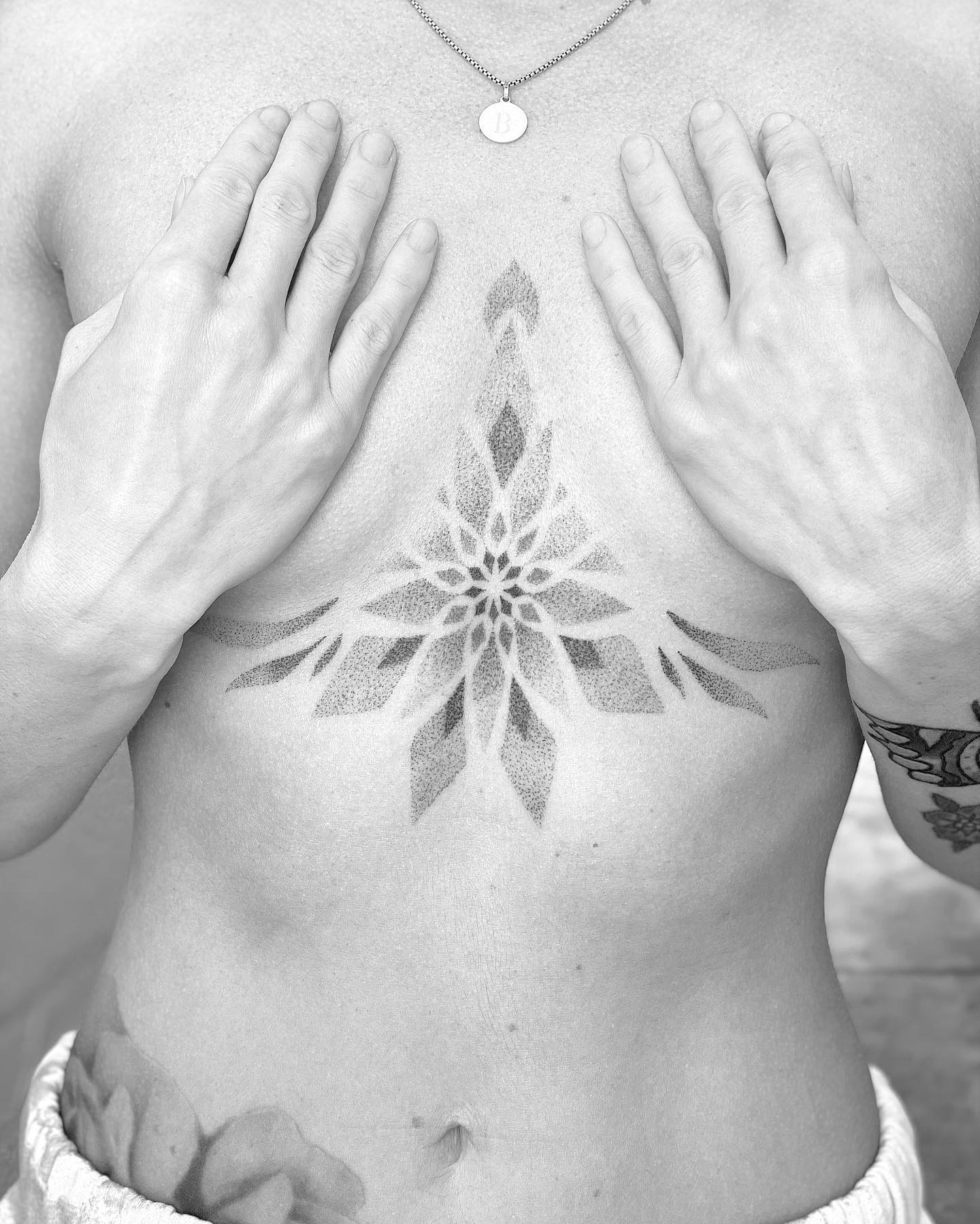 Feminines Brustbein-Tattoo im geometrischen Stil
