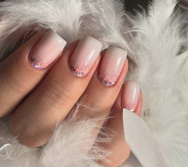 Ombré auf quadratischen kurzen Nägeln mit rosa Ton und Glitzer an der Nagelhaut