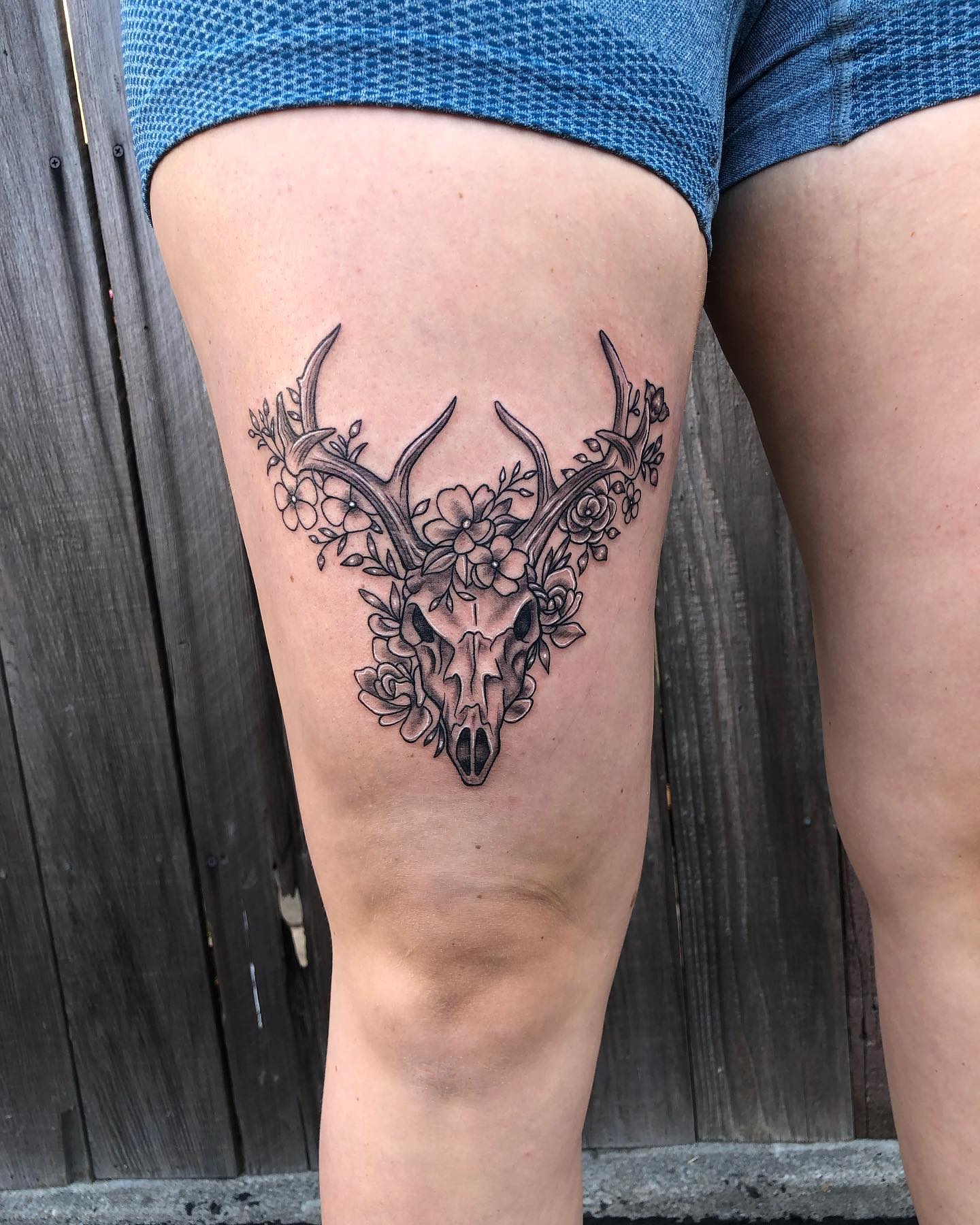 Tatuaż czaszki jelenia z kwiatami