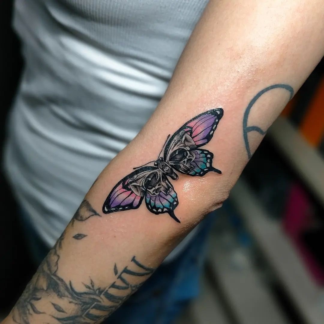 Tatuaż czaszki i motyla na ramieniu