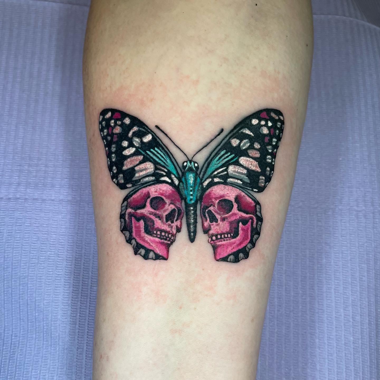 Różowa czaszka i motyl tatuaż