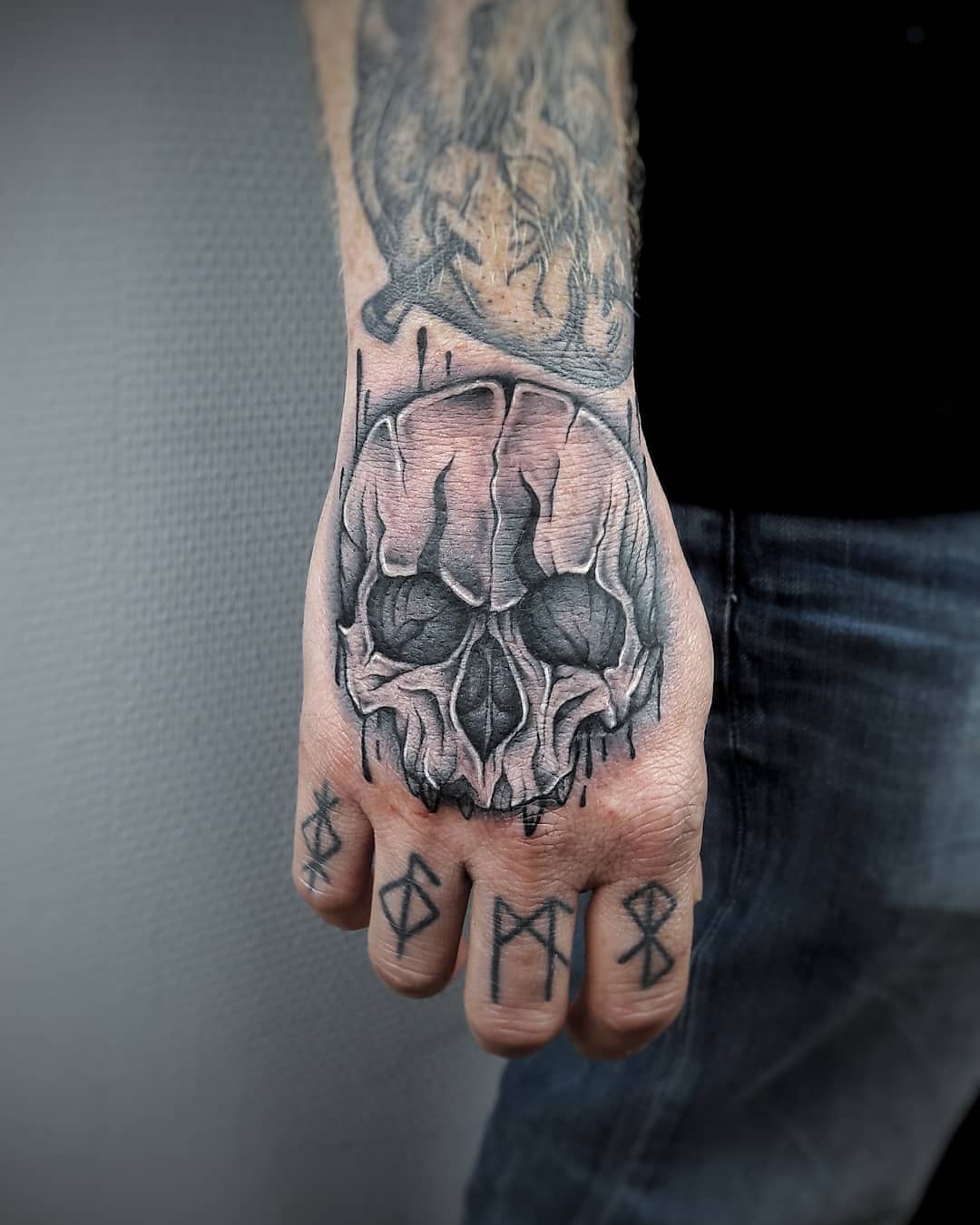 Czarny tatuaż na rękę z czaszką
