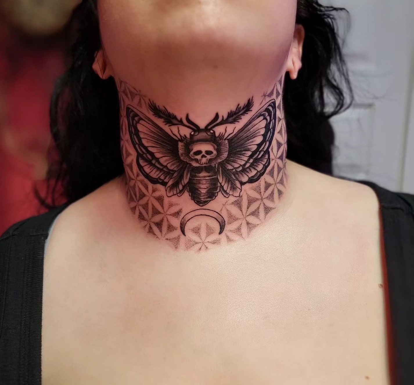Butterfly skull neck tattoo with symbol