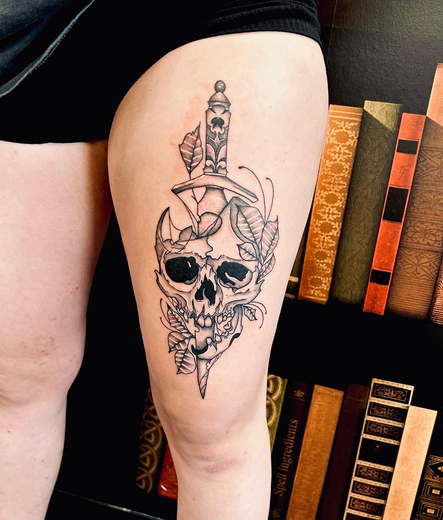 Tatuaż na biodrze z czaszką i nożem