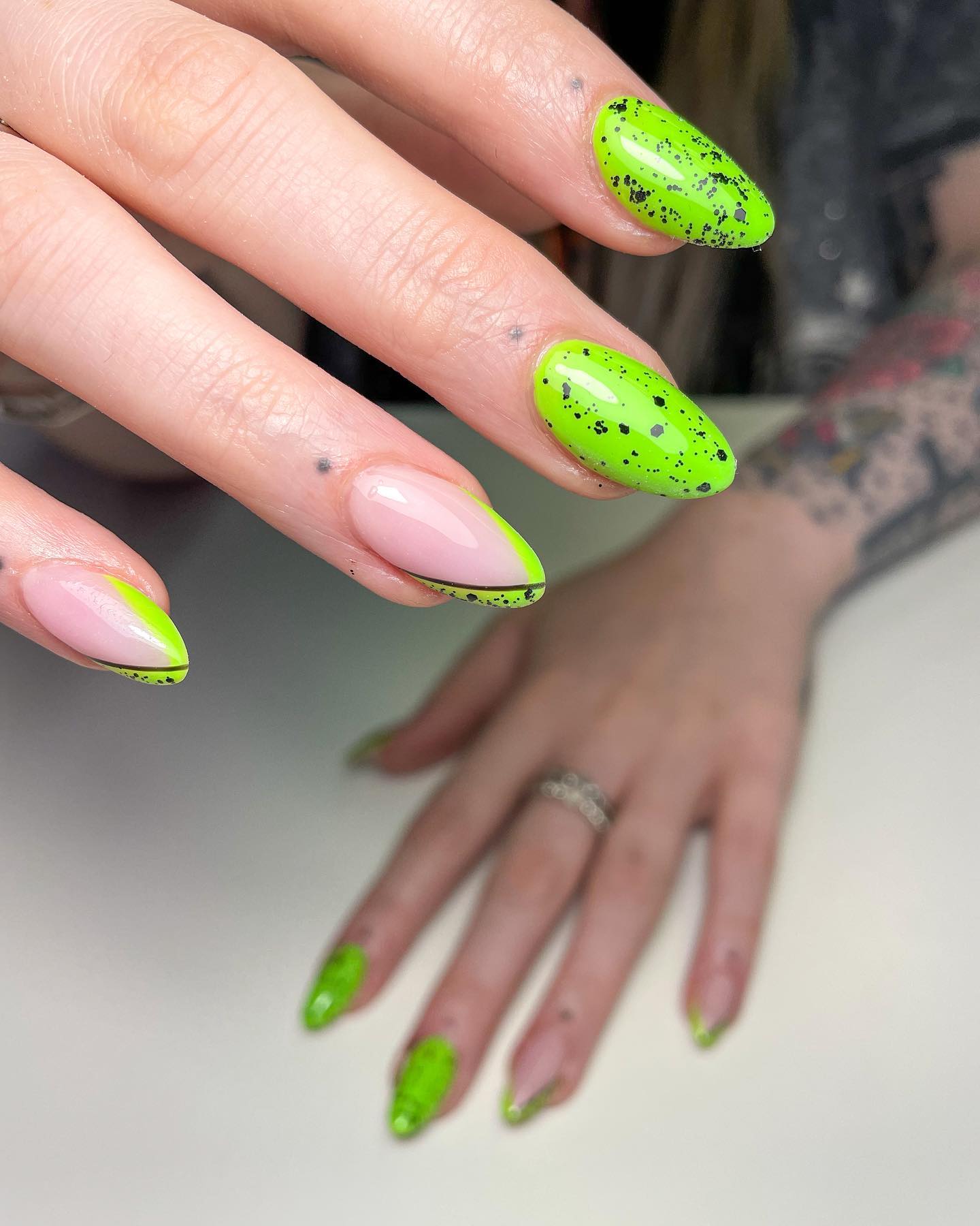 Zbliżenie limonkowo-zielonych paznokci migdałowych z czarnymi plamami
