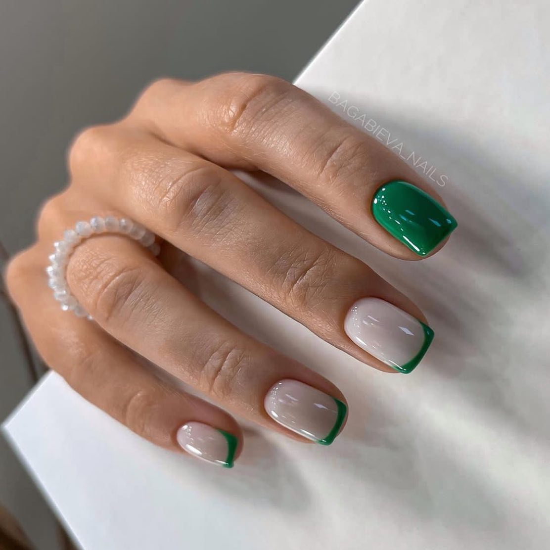 Zbliżenie na krótkie paznokcie z podkładem w kolorze nude i naturalnymi zielonymi tipsami