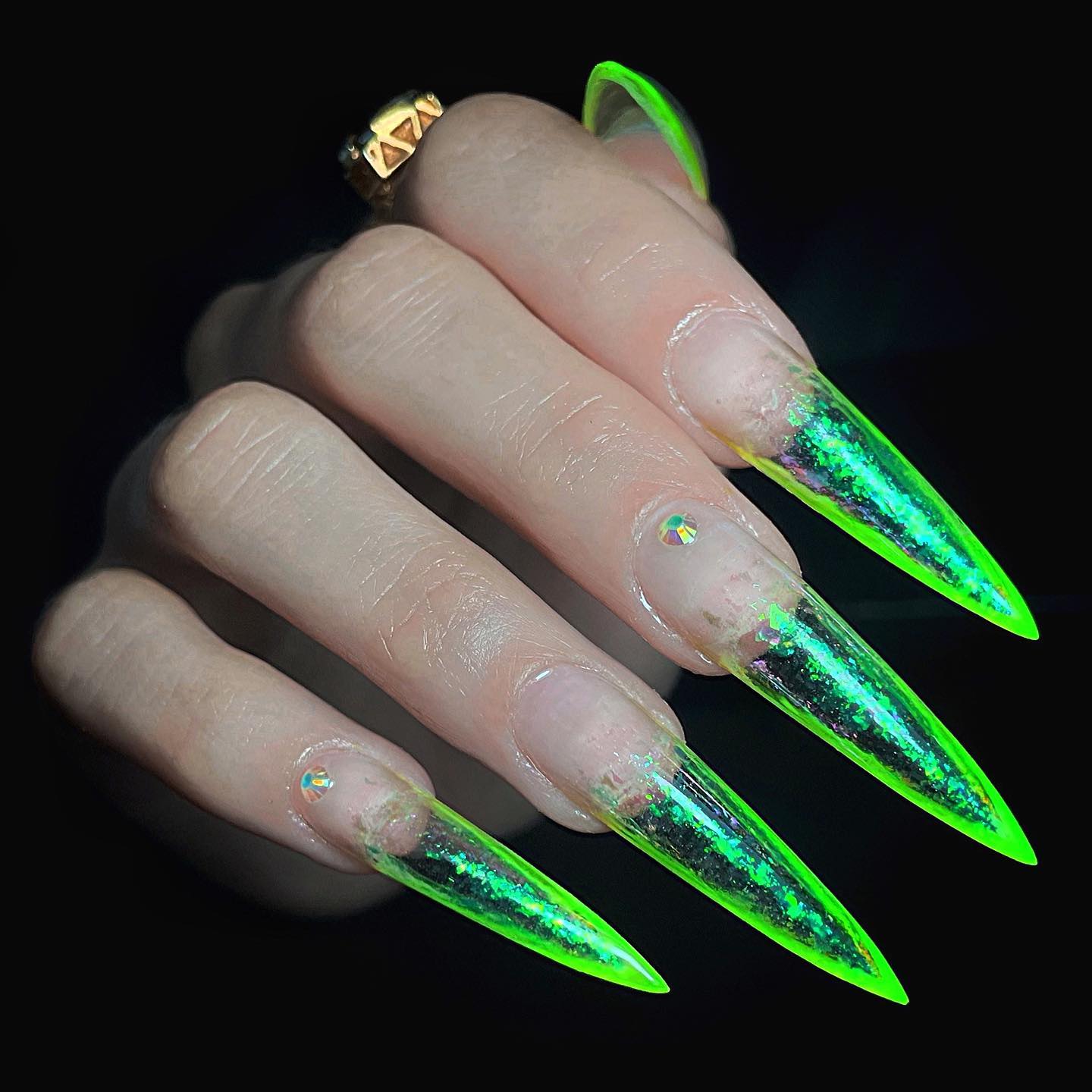 Eine Nahaufnahme langer, klarer Stiletto-Nägel mit Neonverzierung