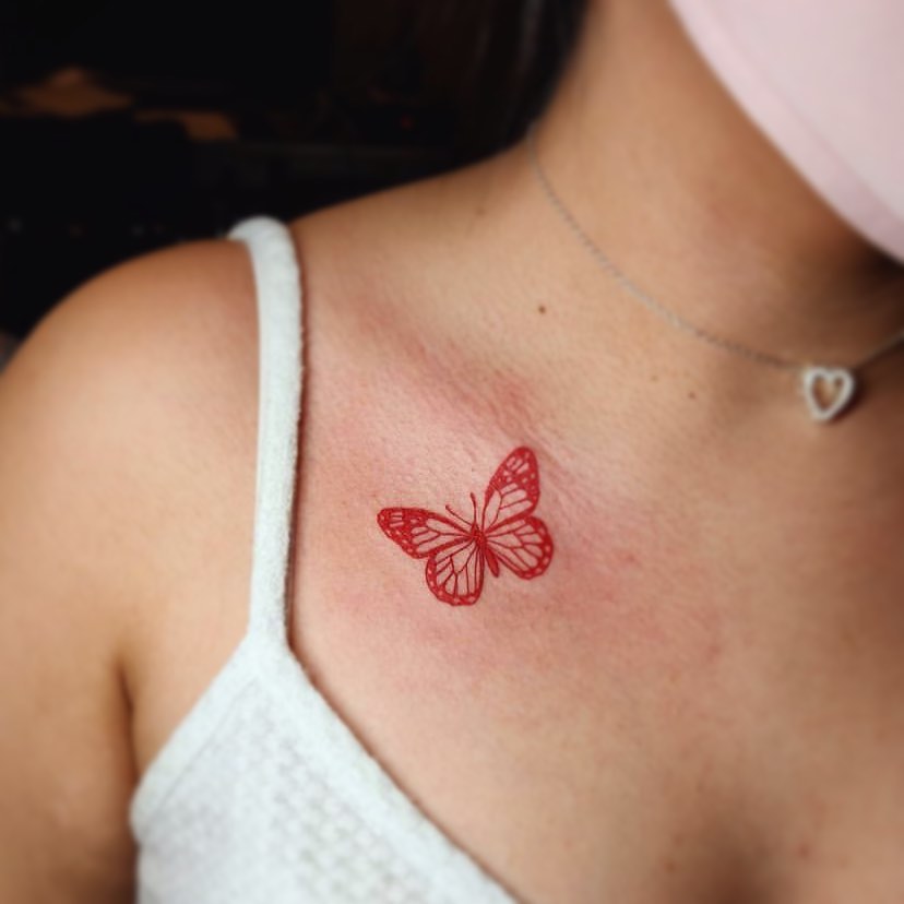 Tatuaż czerwonego motyla monarchy na piersi