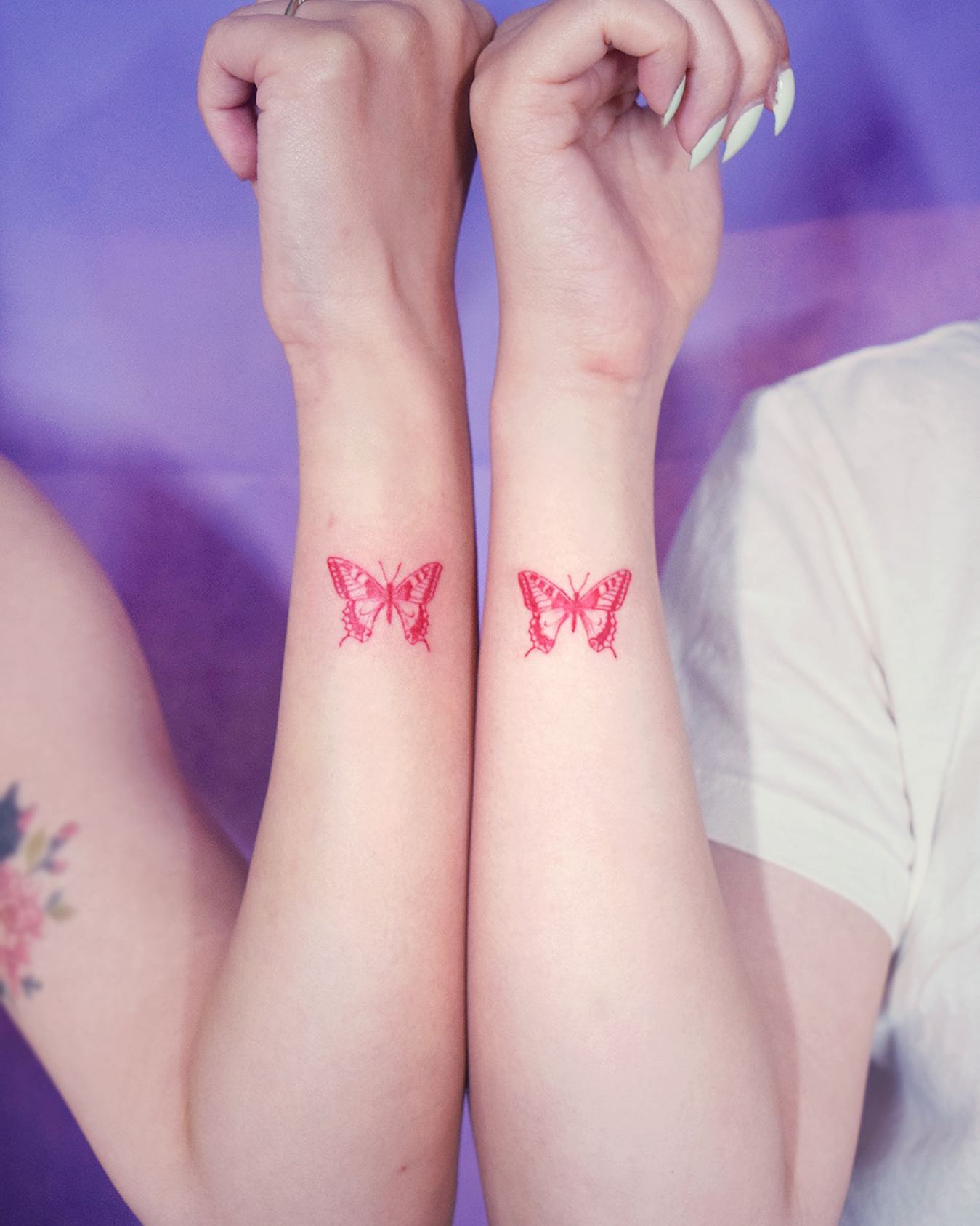 Fine line butterfly tattoo on the wrist.