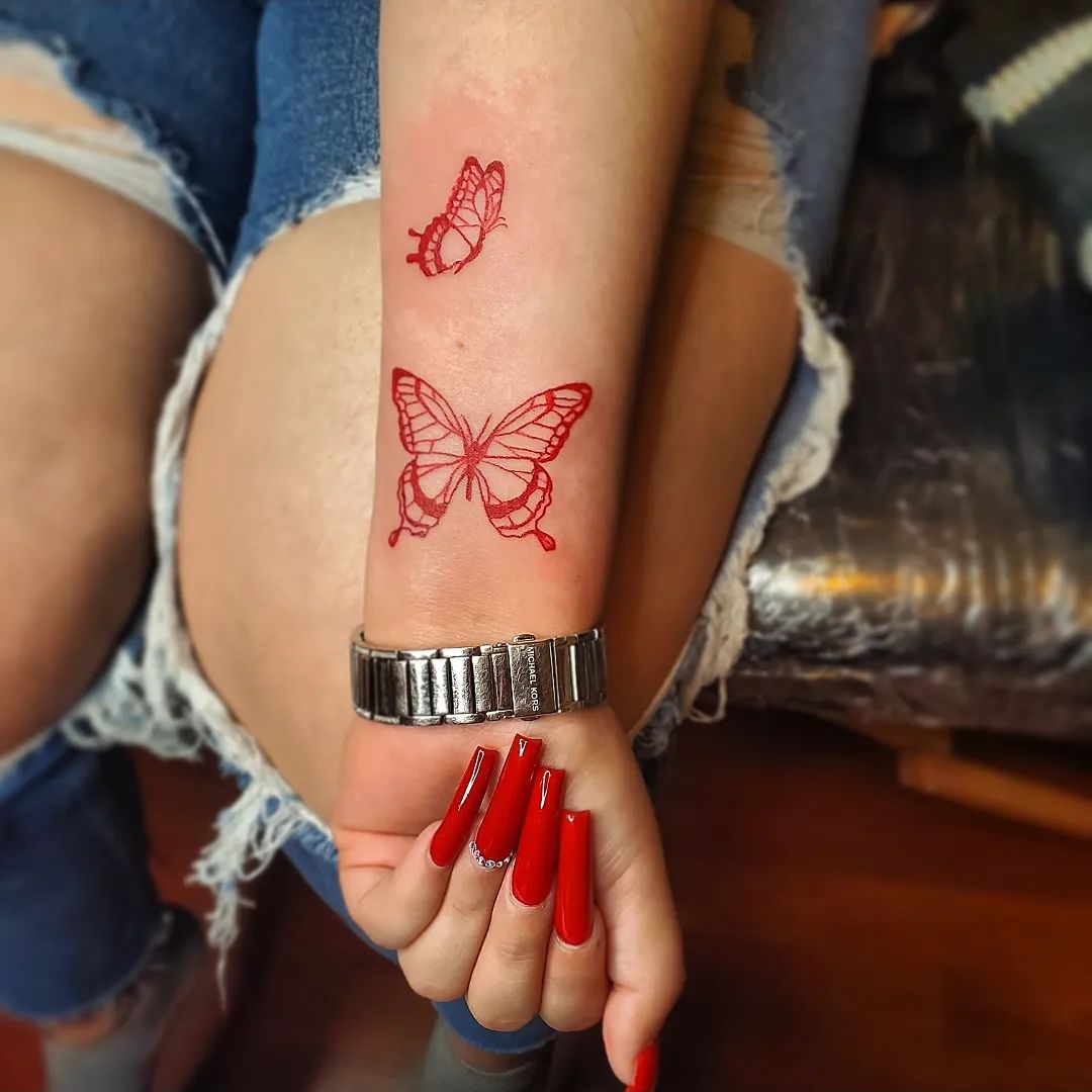 Tattoo mit roten Schmetterlingen am Handgelenk