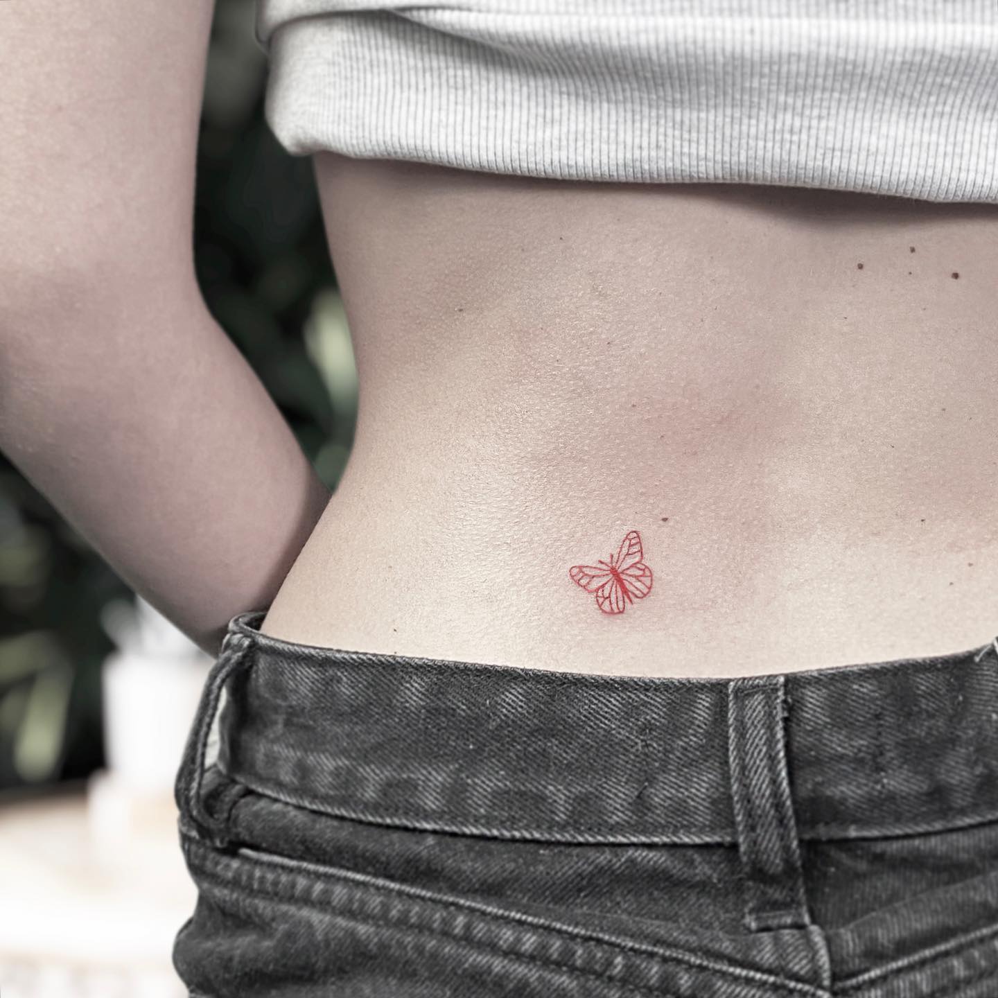 Red butterfly tattoo on back