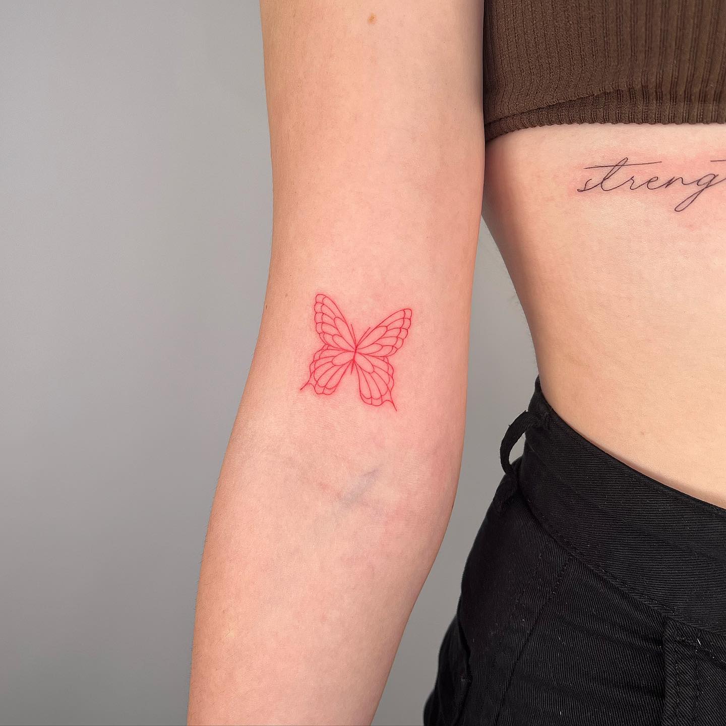 Minimalistic red butterfly tattoo