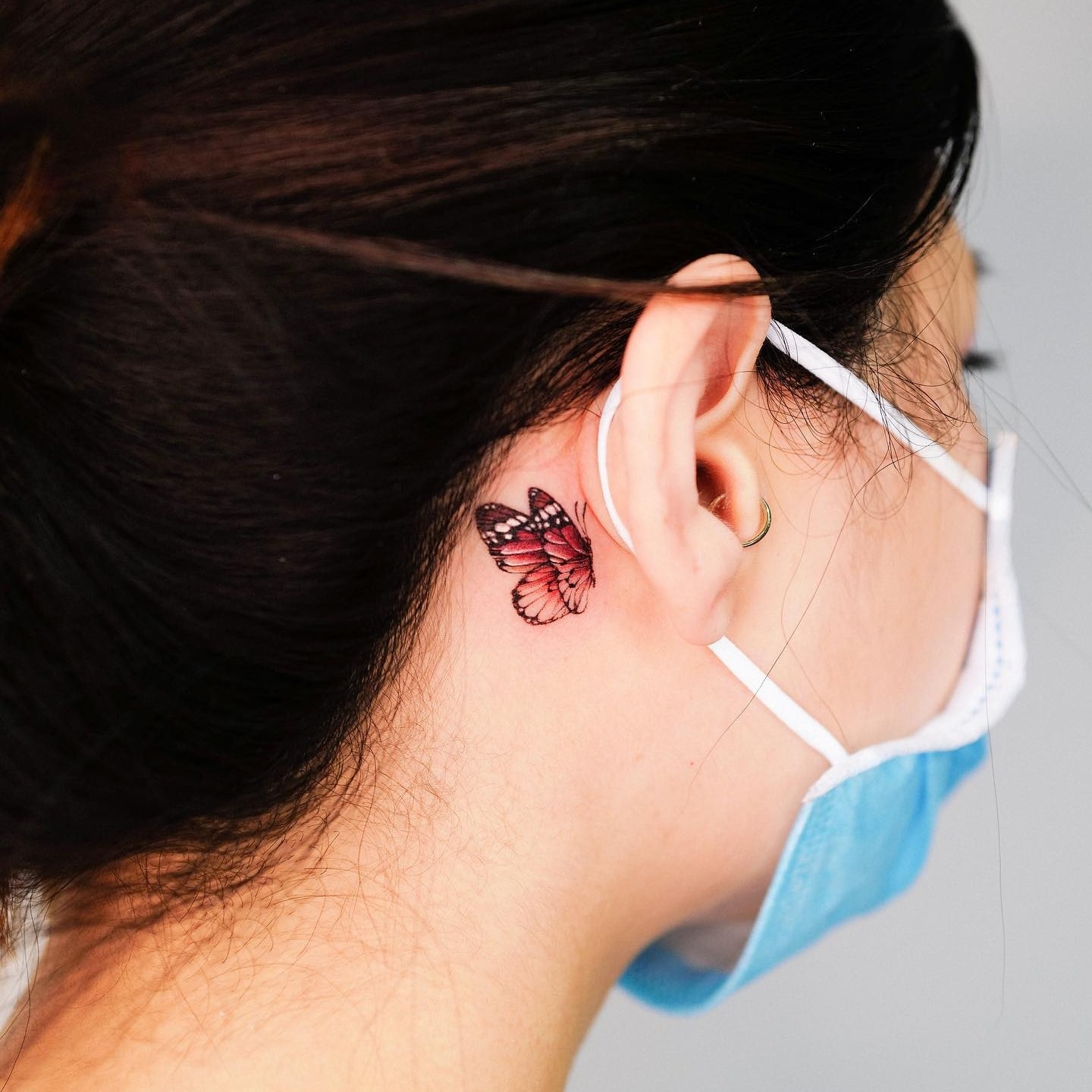 Red admiral tattoo behind ear