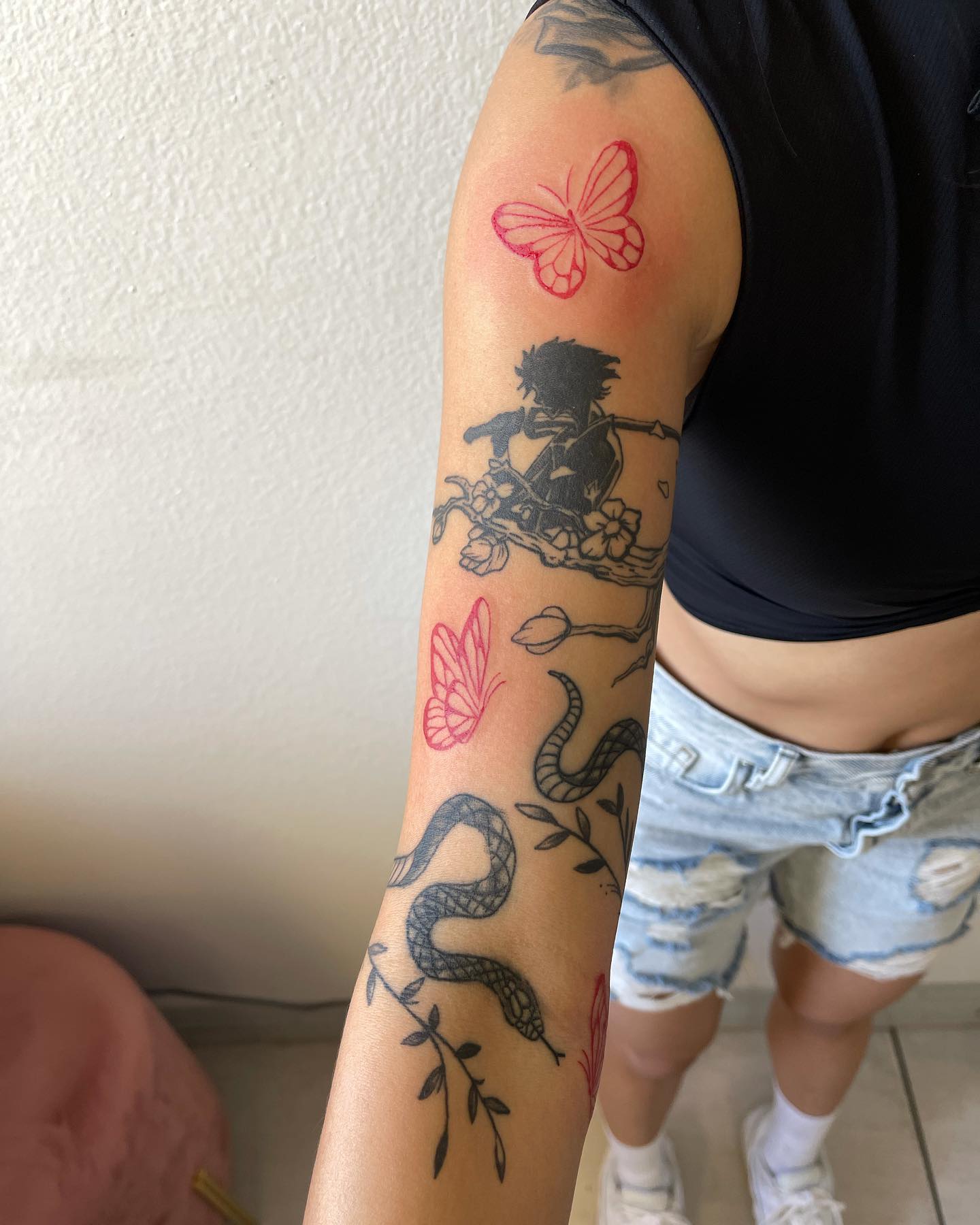 Tatuaż na rękawie z czerwonymi i czarnymi motylami