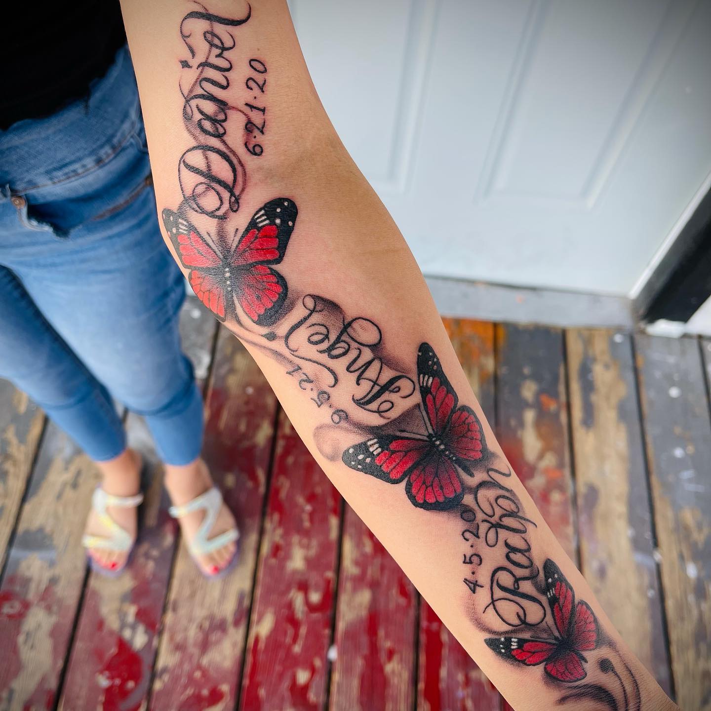 Tatuaż czerwonego motyla na ramieniu