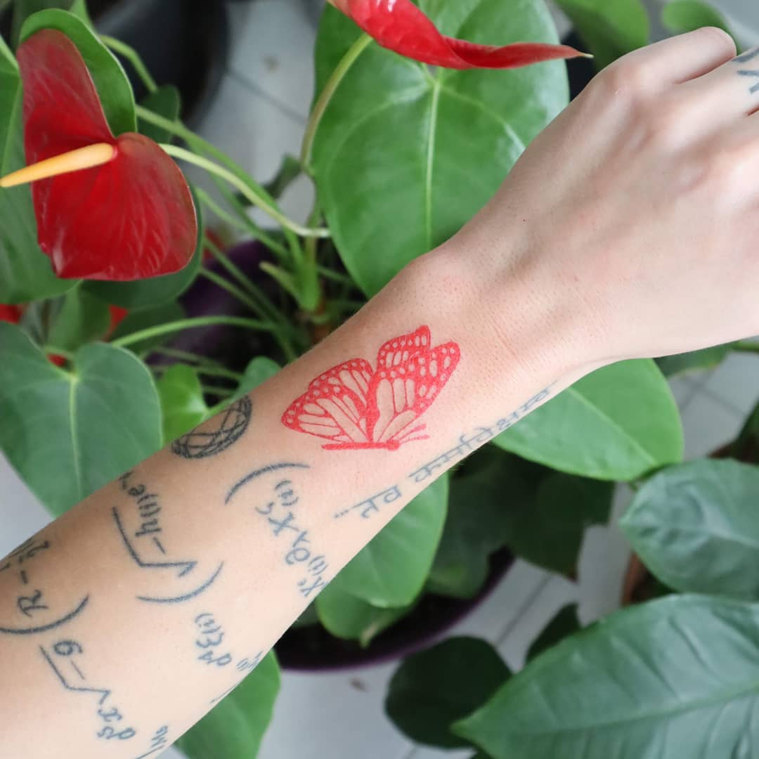 Red butterfly tattoo with inscriptions
