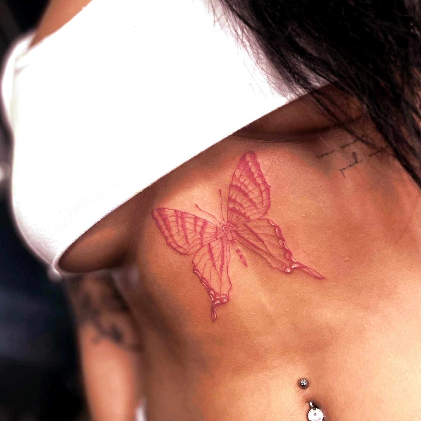 Tatuaż czerwonego motyla na brzuchu