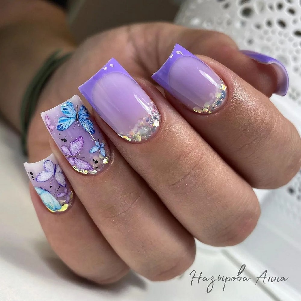 Lila Acrylnägel mit blauen Schmetterlingen