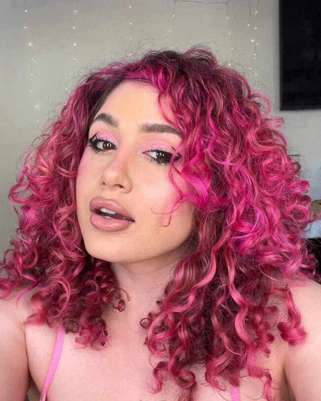 Розовый балаяж на кудрявых волосах