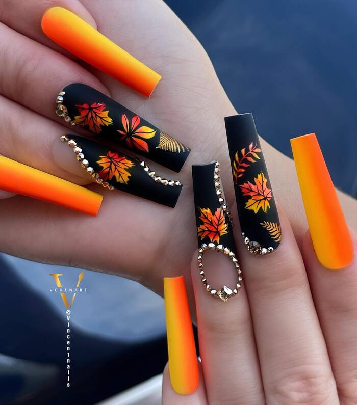 Close-Up Photo of Matte Black And Orange Fall Manicure