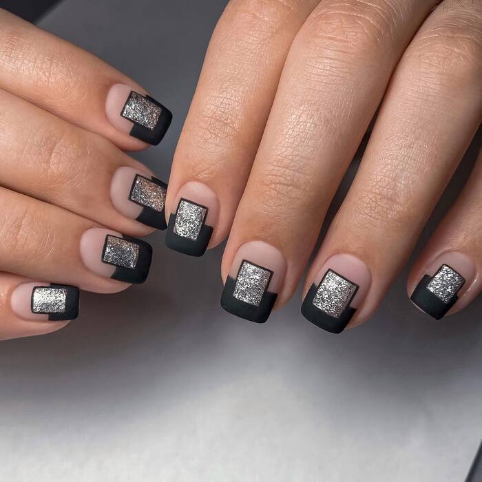 Close-Up Photo of Matte Black And Silver Nail Art