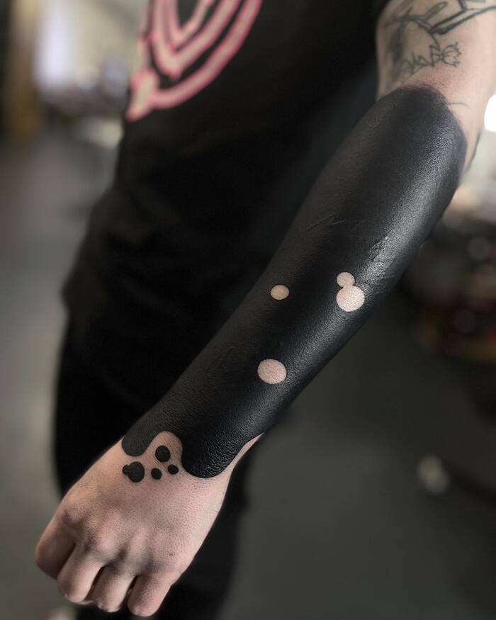 Minimalist half sleeve blackout tattoo
