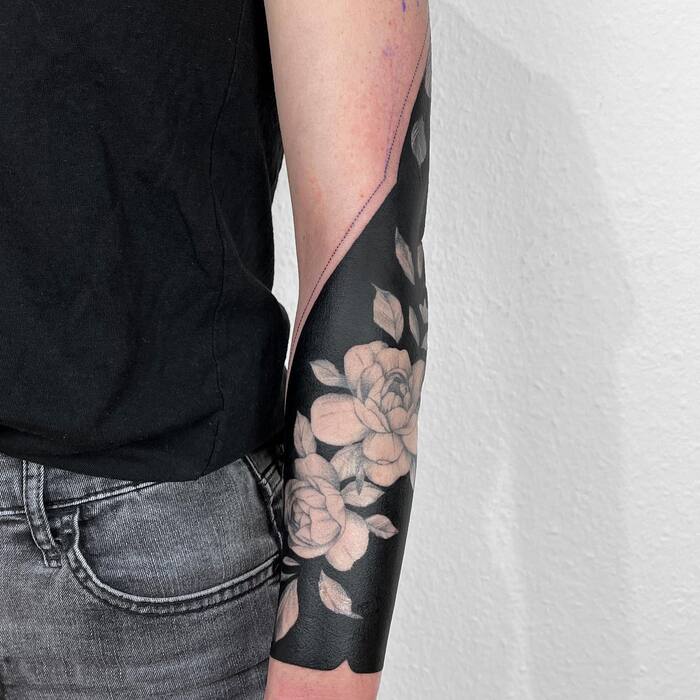 White ink blackout rose tattoo on arm
