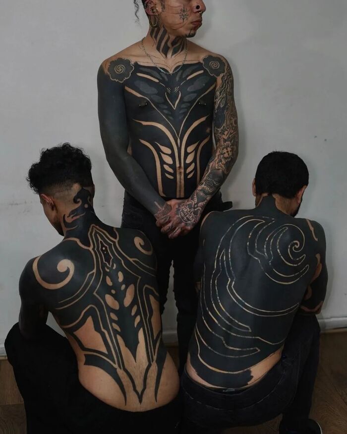 Men full body blackout tattoo in tribal style 