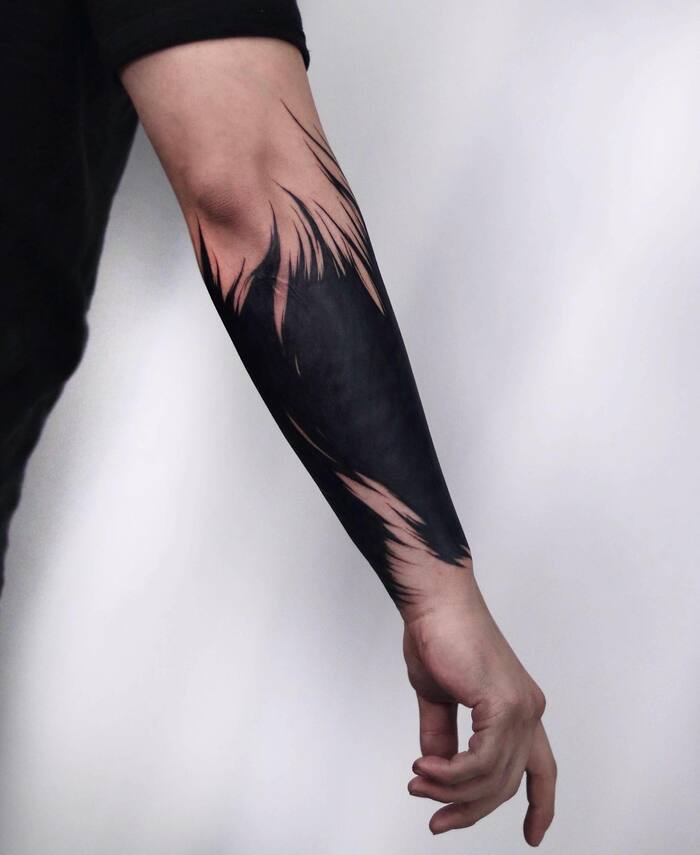 Minimalist blackout forearm tattoo
