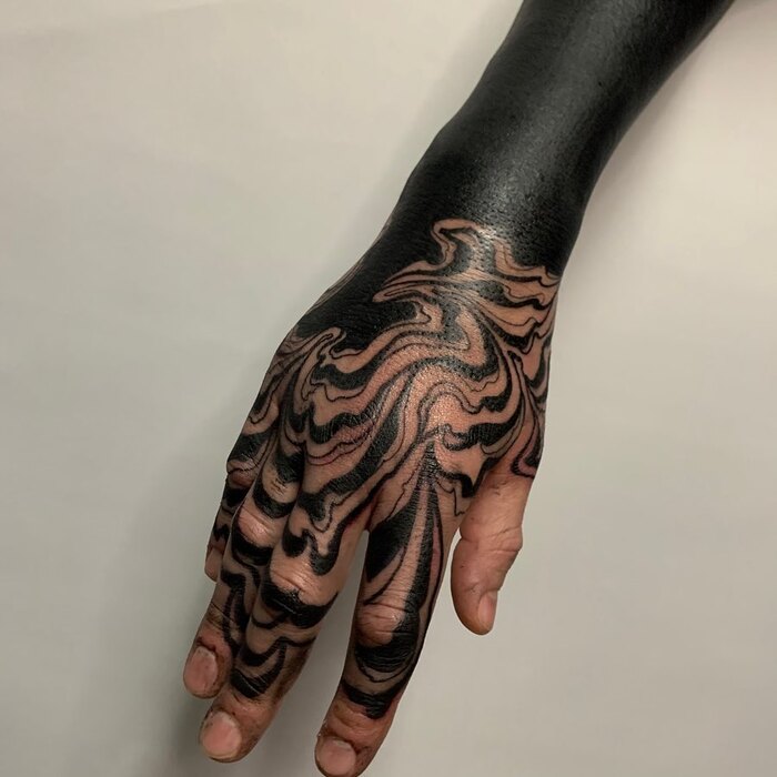Abstract blackout tattoo on hand 