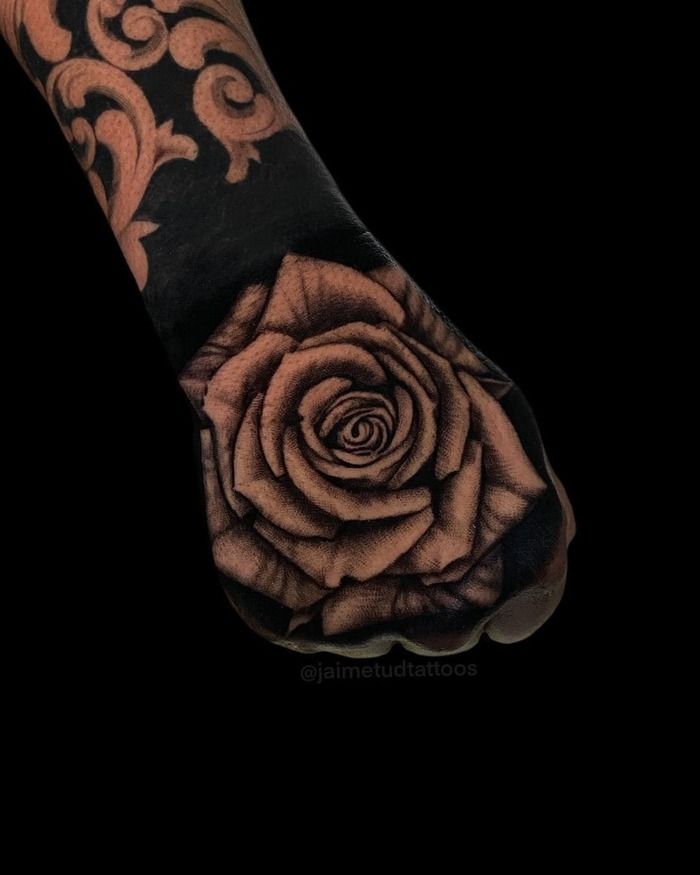 Negative space blackout rose tattoo on hand