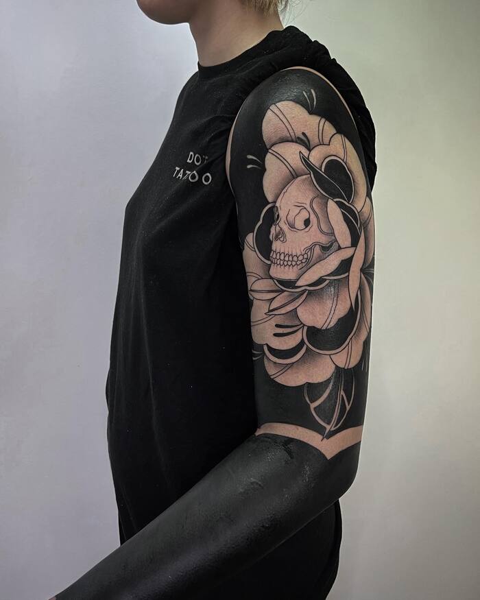 Blackout sleeve tattoo in form of skull 