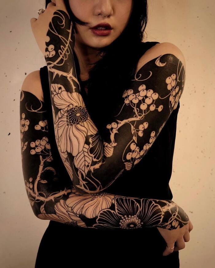 Hibiscus flower blackout sleeve tattoo