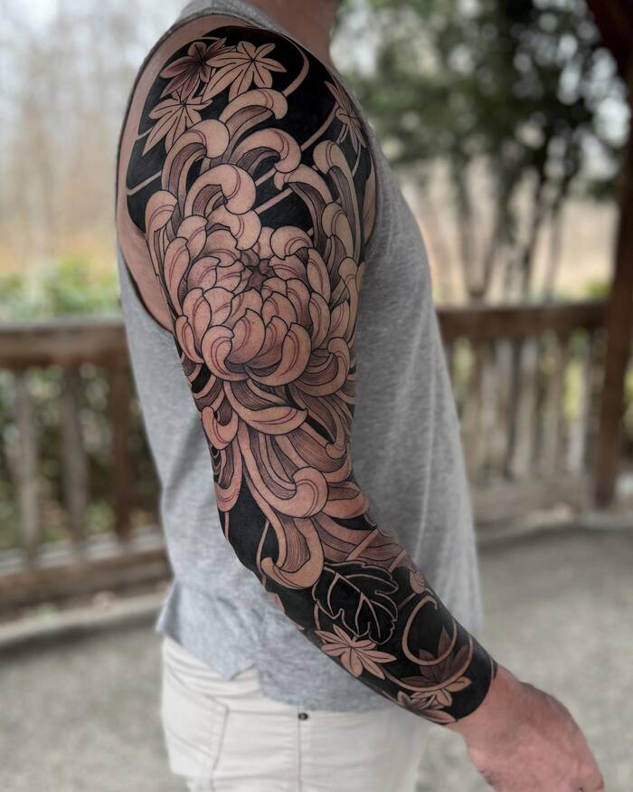 Japanese flower blackout sleeve negative space tattoo