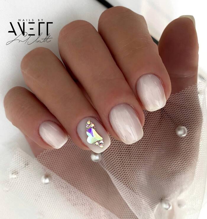 Short wedding manicure with rhinestones accent on the ring finger