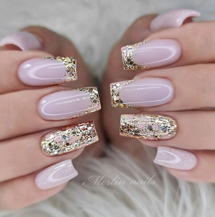 Pastel pink nails with gold glitter decoration