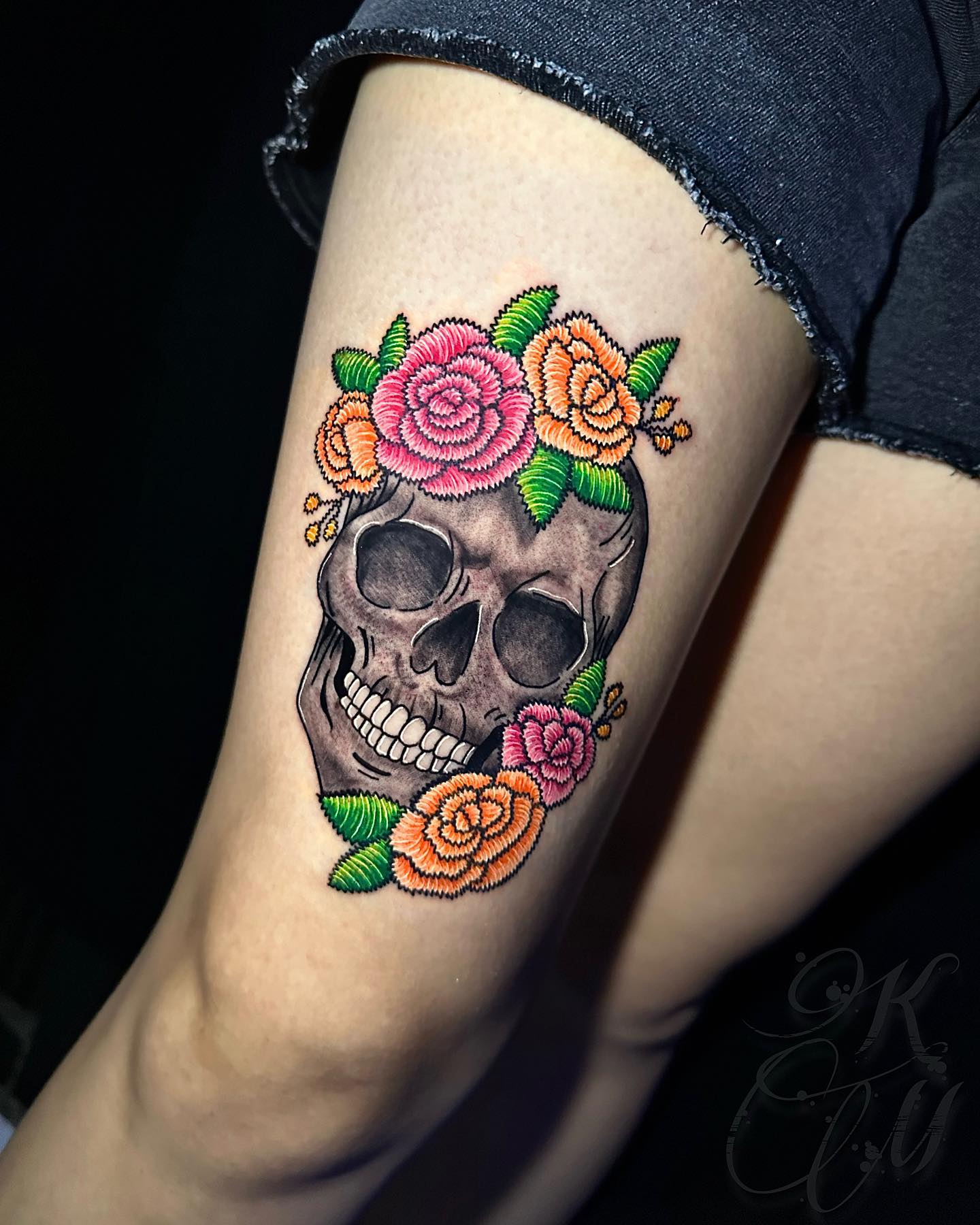 Realistic skull tattoo surrounded by embroidery of roses
