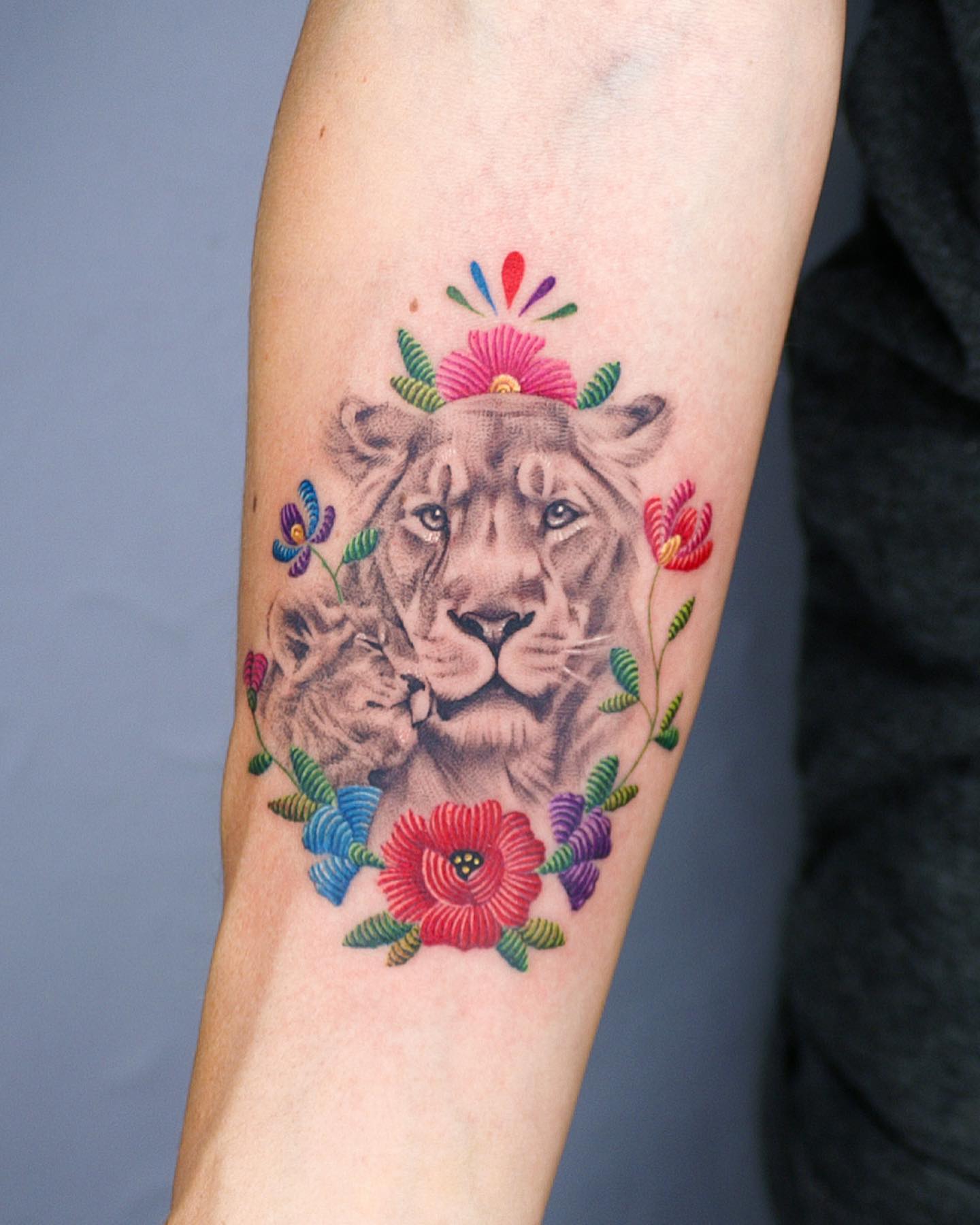 Realistyczny tatuaż lwa w połączeniu ze szwami kwiatowymi