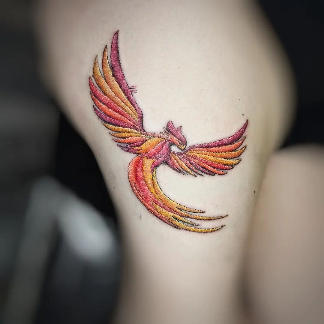 Flying red and orange phoenix tattoo