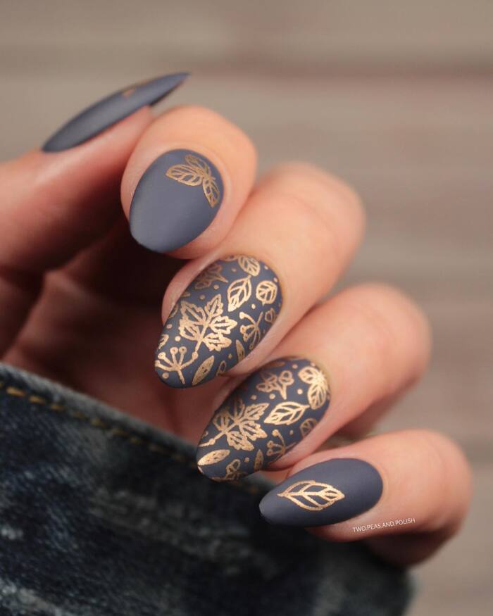 Close-up photo of Black Matte Manicure With Gold Leaf Pattern