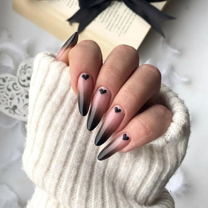 Close-up photo of Black Ombre Nails With Little Hearts