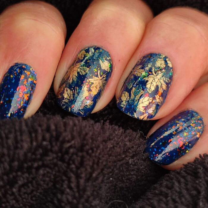 Close-up photo of Short Blue Nails With Golden Leaves
