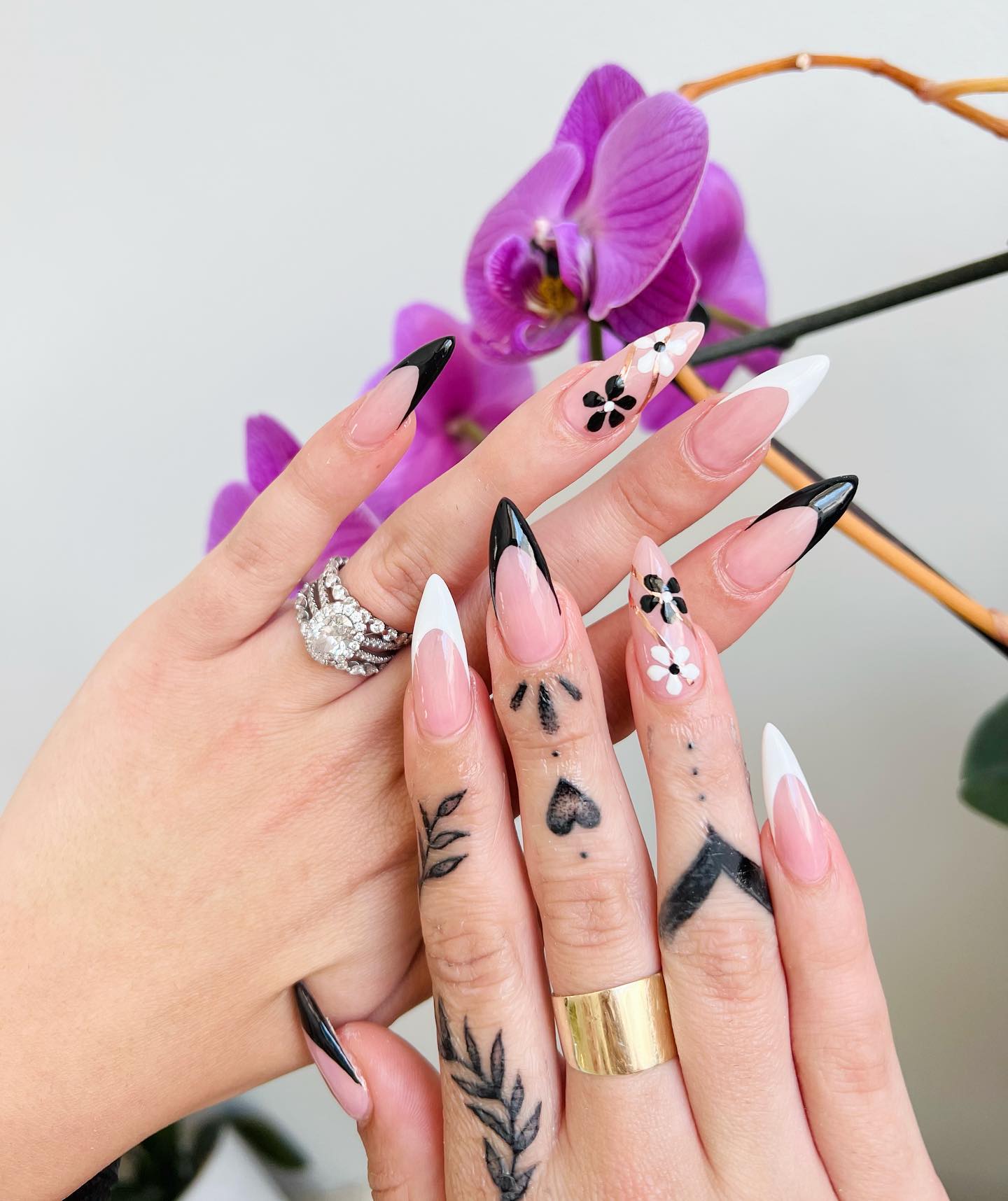 Black And White almond Nails with one black one white flowers on ring finger
